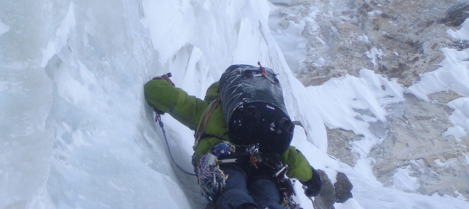 An ice climber using a CRUX roll-top pack